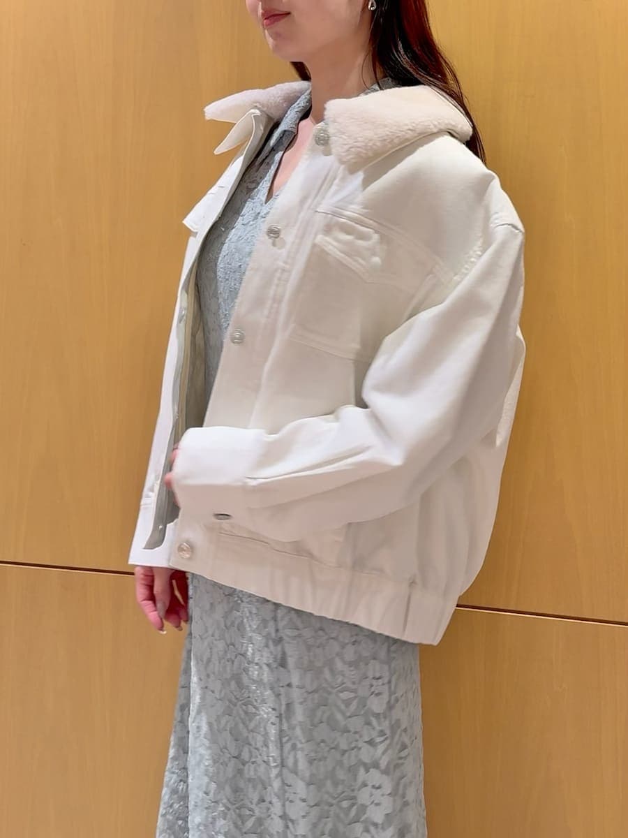 ホワイト系のブルゾン、グリーン系のワンピースを着用したレディースの冬コーディネートの6枚目の写真