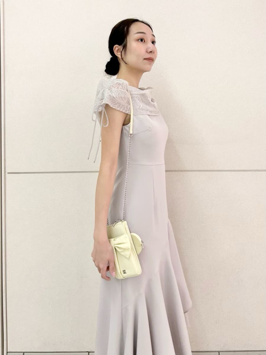 グレー系のドレス、ブラウン系のパンプス、イエロー系のショルダーバッグを着用したレディースの春コーディネートの5枚目の写真