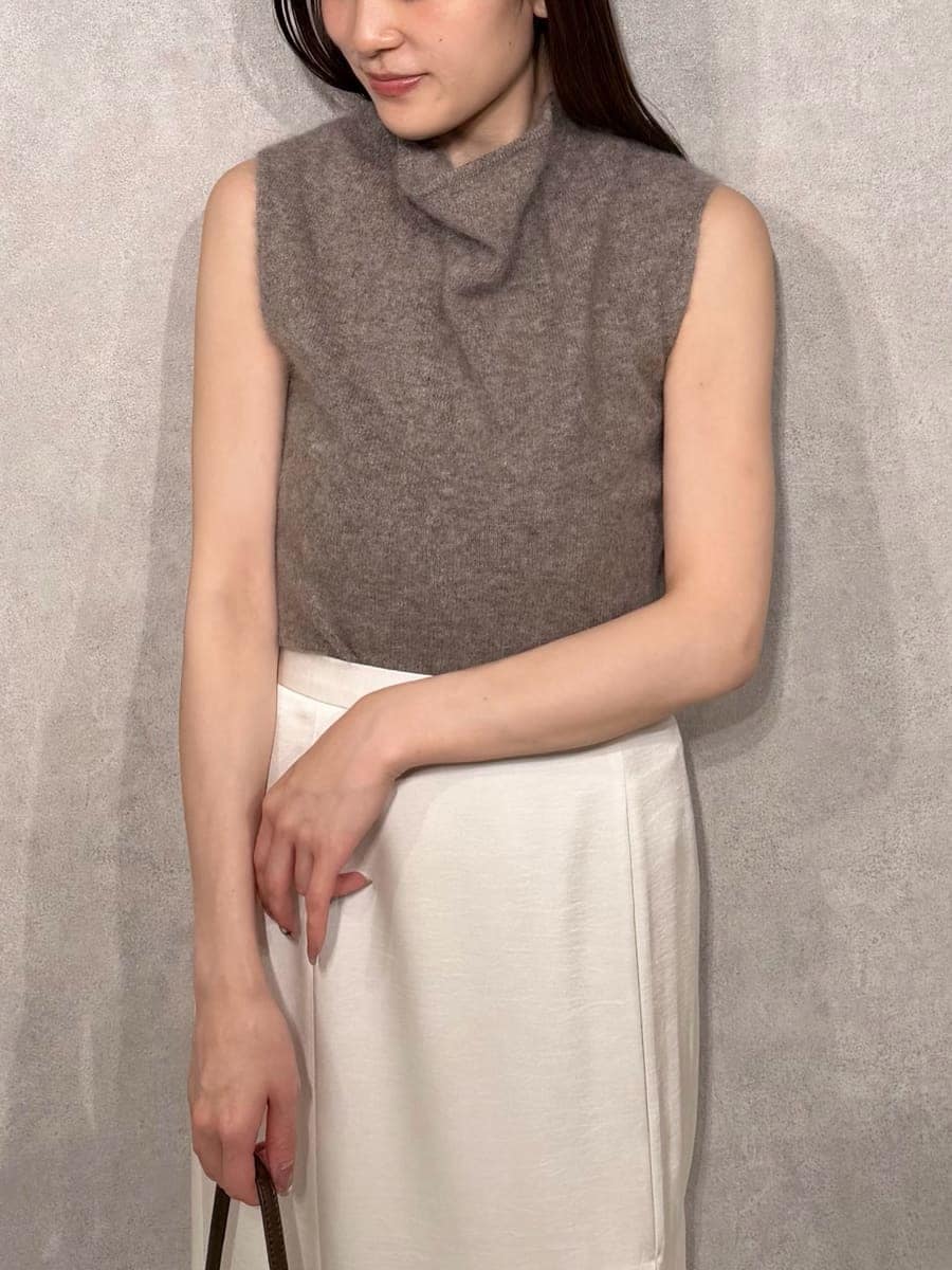 ベージュ系のトレンチコート、ホワイト系のスカート、ブラウン系のTシャツ/カットソーを着用したレディースの秋コーディネートの8枚目の写真