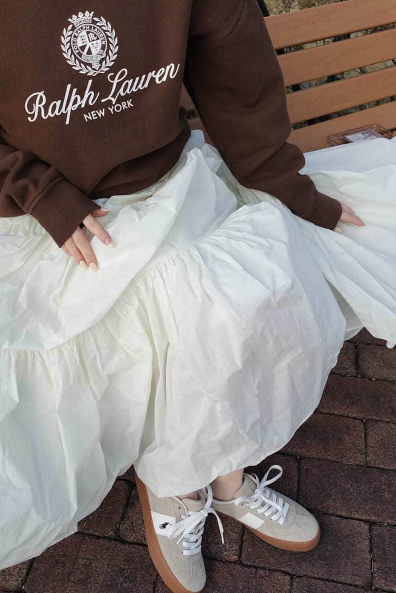 ホワイト系のスカート、ブラウン系のスウェット、ベージュ系のスニーカーを着用したレディースの春コーディネートの5枚目の写真