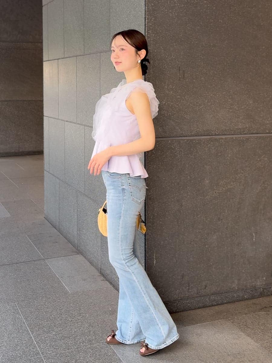 ブルー系のデニムパンツ、ブラック系のかごバッグ、パープル系のニット/セーターを着用したレディースの夏コーディネートの3枚目の写真