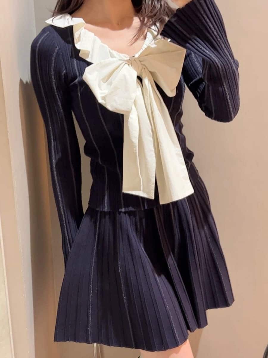 ブラック系のブーツ、ブルー系のチェスターコート、ブルー系のワンピースを着用したレディースの冬コーディネートの7枚目の写真