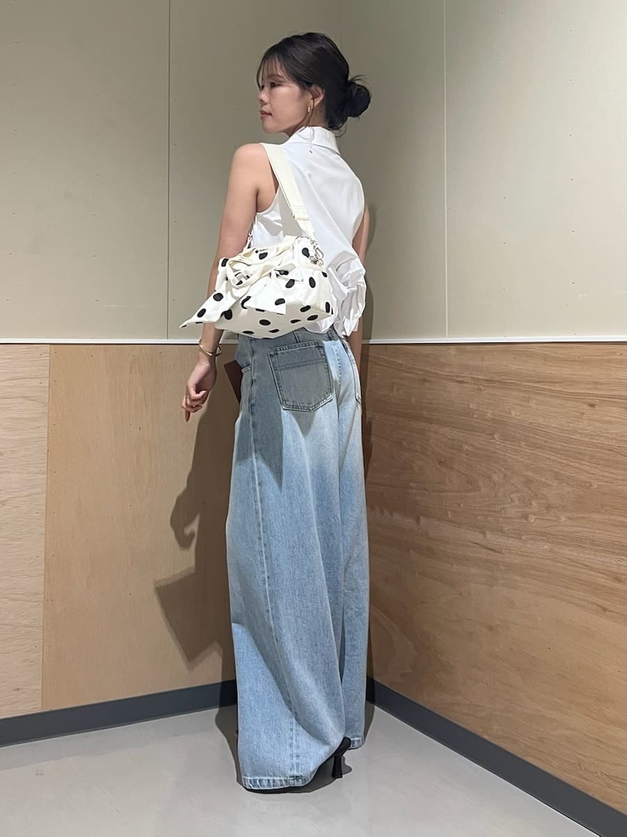 ブルー系のデニムパンツ、ホワイト系のシャツ/ブラウス、ホワイト系のショルダーバッグを着用したレディースの夏コーディネートの2枚目の写真