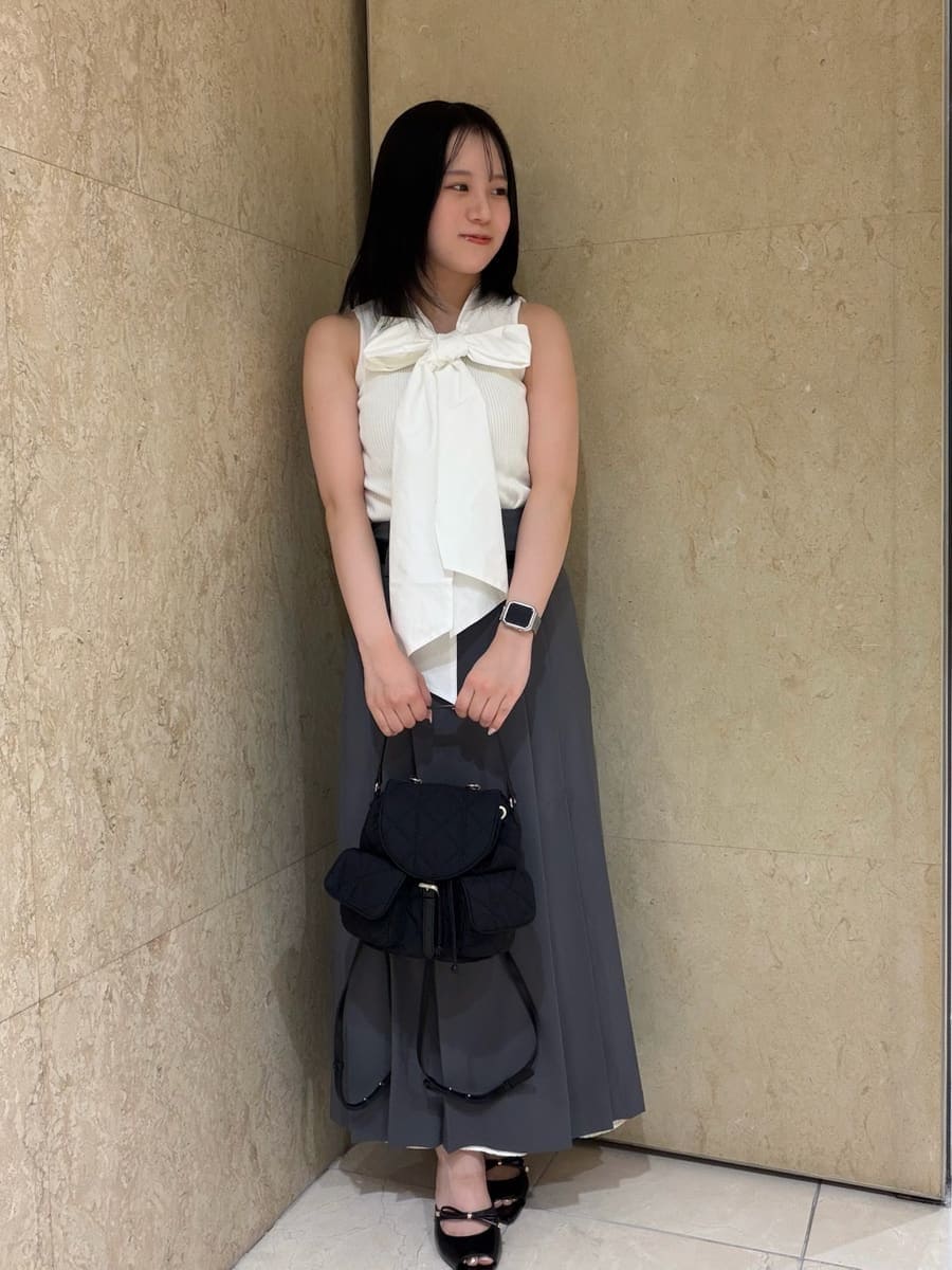 グレー系のスカート、ホワイト系のTシャツ/カットソー、ブラック系のサンダルを着用したレディースの夏コーディネートの2枚目の写真