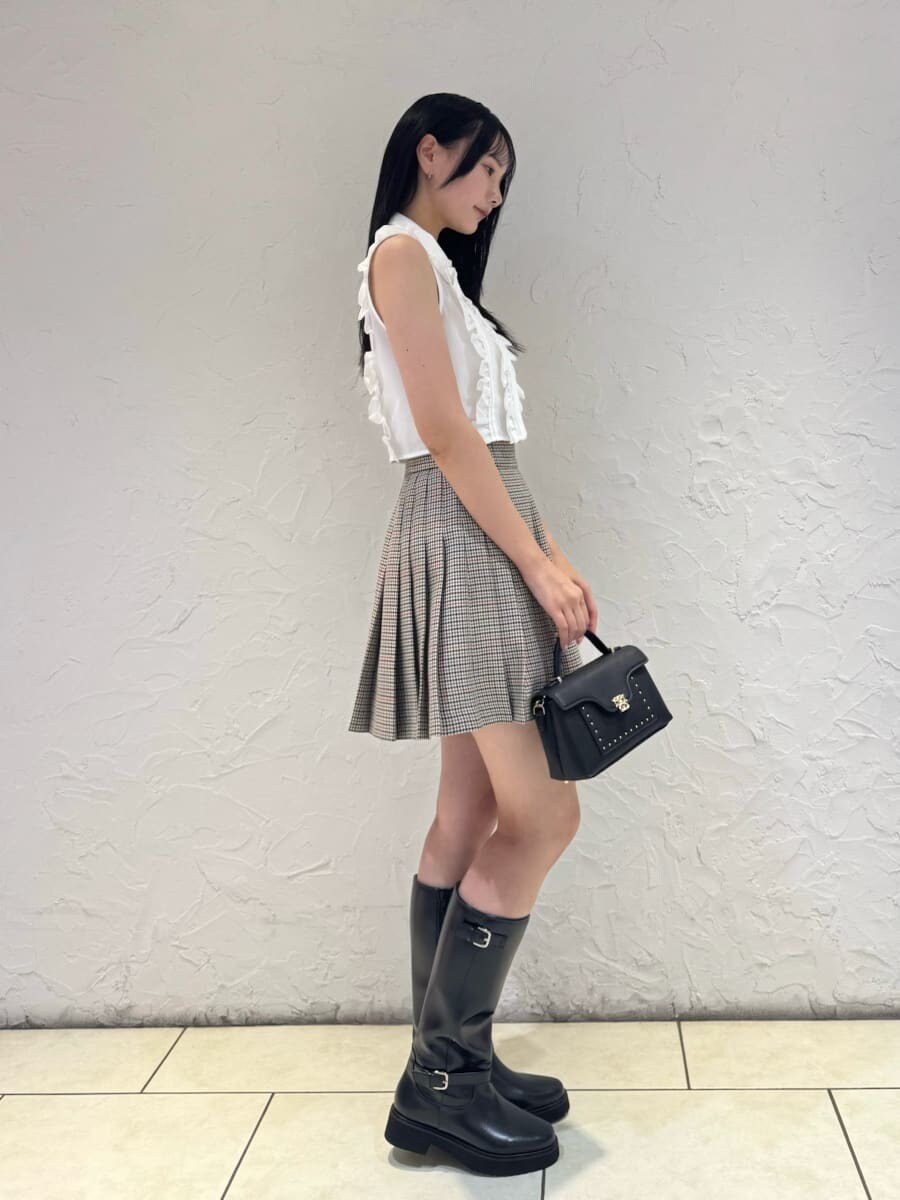ホワイト系のシャツ/ブラウス、ベージュ系のスカート、ブラック系のブーツを着用したレディースの夏コーディネートの2枚目の写真