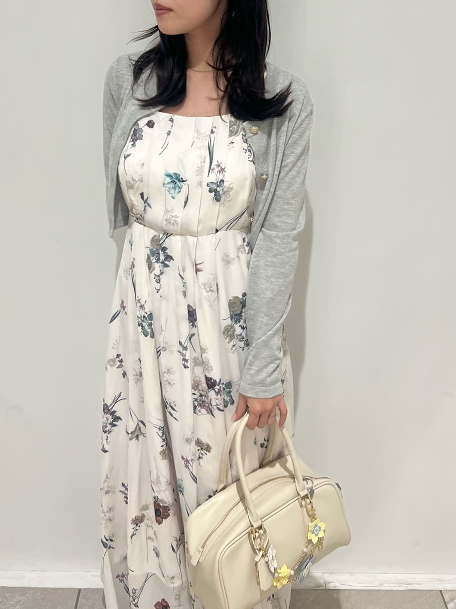 グレー系のブーツ、ホワイト系のワンピース、ホワイト系のボストンバッグを着用したレディースの冬コーディネートの5枚目の写真