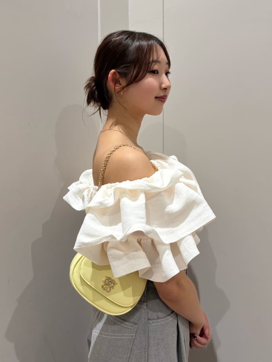 グレー系のデニムパンツ、ホワイト系のシャツ/ブラウス、イエロー系のショルダーバッグを着用したレディースの春コーディネートの6枚目の写真