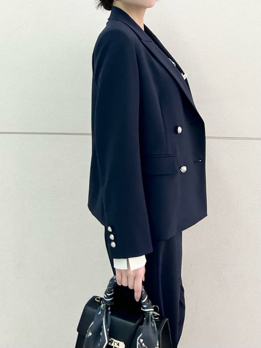 ブルー系のテーラードジャケット、ブルー系のスラックス、ブラック系のハンドバッグを着用したレディースの冬コーディネートの8枚目の写真