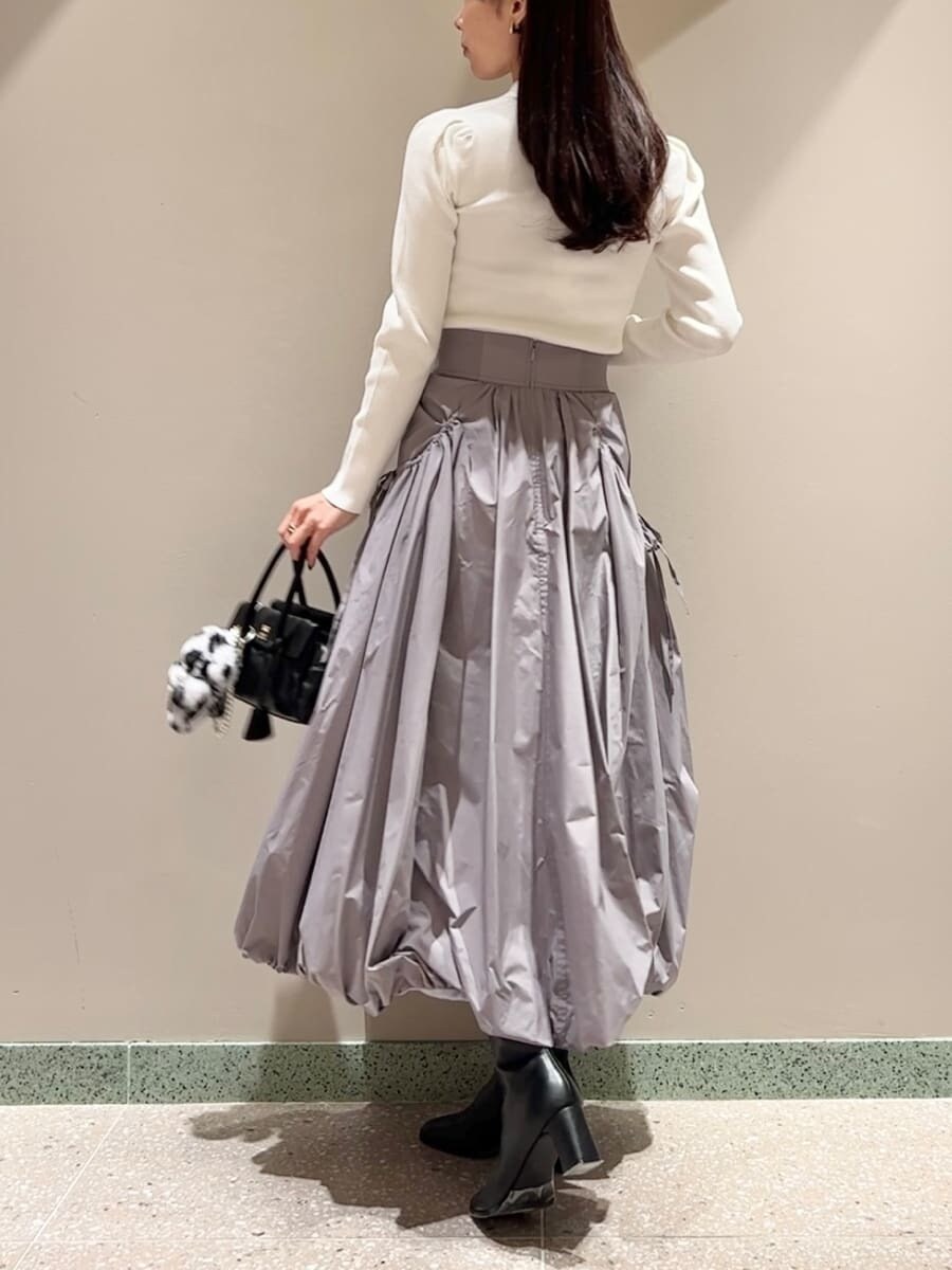 ホワイト系のニット/セーター、グレー系のスカート、ブラック系のボストンバッグを着用したレディースの秋コーディネートの4枚目の写真