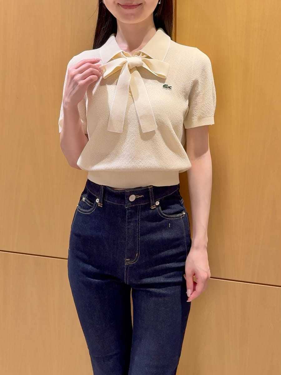 ブルー系のデニムパンツ、ホワイト系のショルダーバッグを着用したレディースの春コーディネートの4枚目の写真