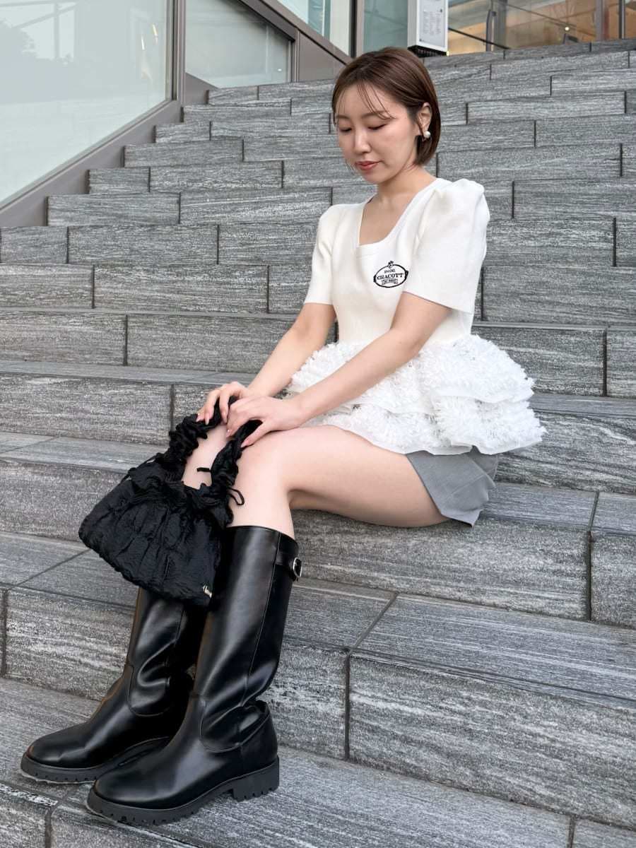 ホワイト系のニット/セーター、グレー系のその他パンツを着用したレディースの春コーディネートの2枚目の写真