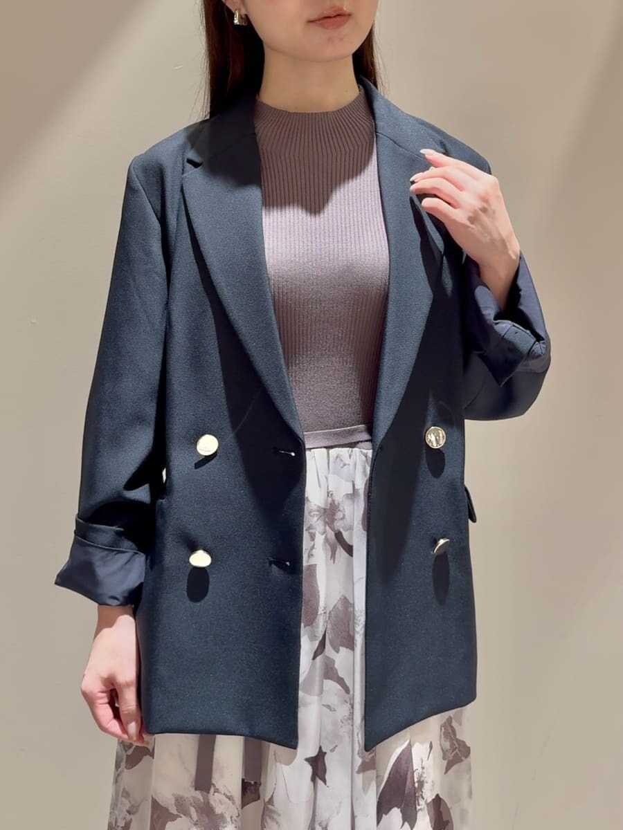 ブルー系のテーラードジャケット、グレー系のワンピース、ブラック系のブーツを着用したレディースの秋コーディネートの4枚目の写真