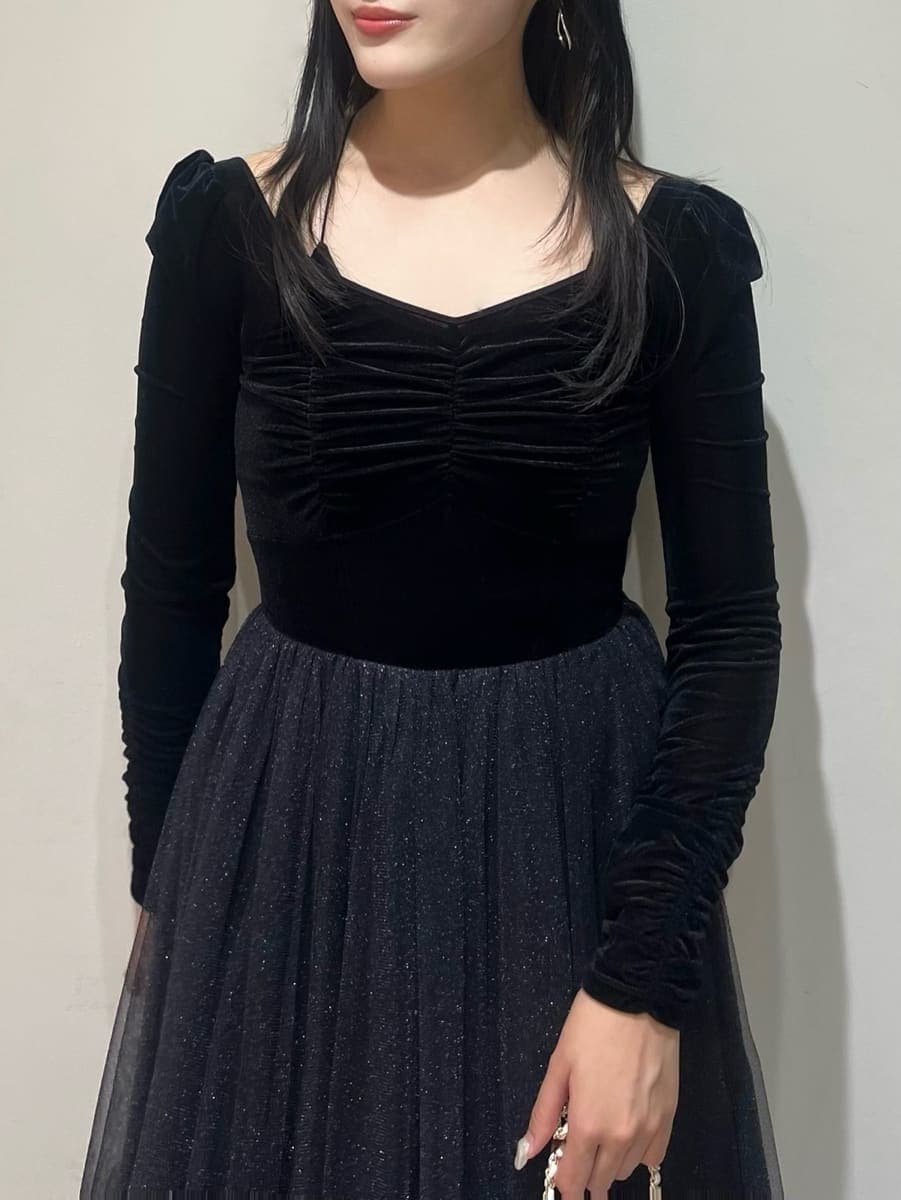 ブラック系のワンピース、ホワイト系のショルダーバッグ、ブラック系のブーツを着用したレディースの夏コーディネートの3枚目の写真