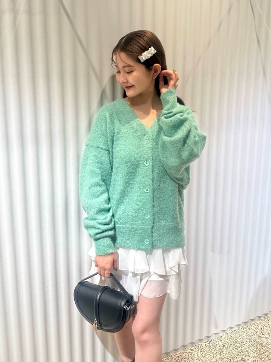 グリーン系のカーディガン/ボレロ、ホワイト系のその他パンツ、ブラック系のハンドバッグを着用したレディースの秋コーディネートの5枚目の写真