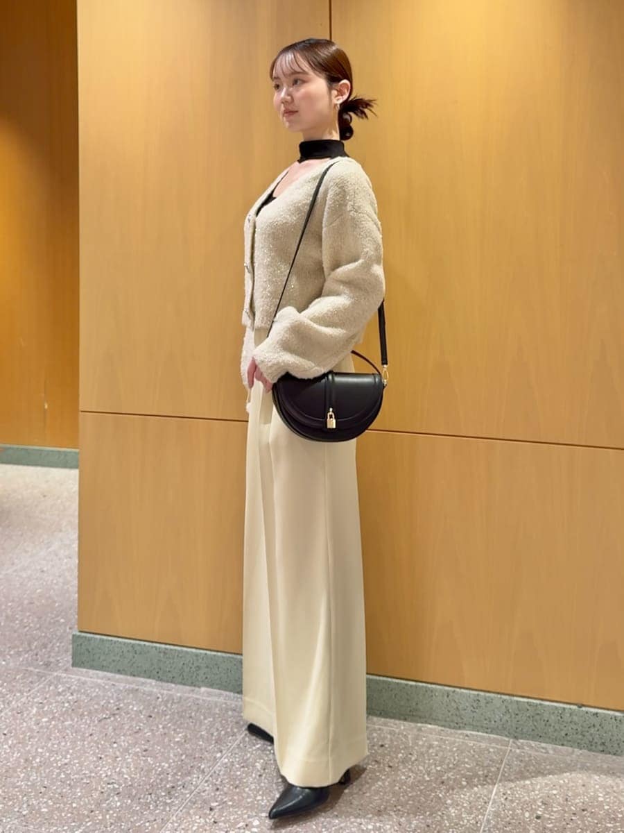 ホワイト系のカーディガン/ボレロ、ブラック系のニット/セーター、ブラック系のブーツを着用したレディースの秋コーディネートの2枚目の写真