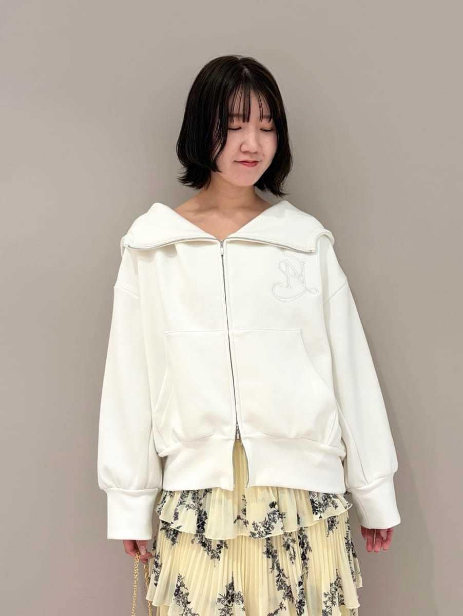 ホワイト系のパーカー、イエロー系のスカート、ホワイト系のショルダーバッグを着用したレディースの冬コーディネートの2枚目の写真