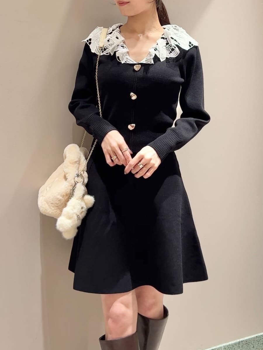 ホワイト系のステンカラーコート、イエロー系のハンドバッグ、ブラック系のワンピースを着用したレディースの冬コーディネートの8枚目の写真