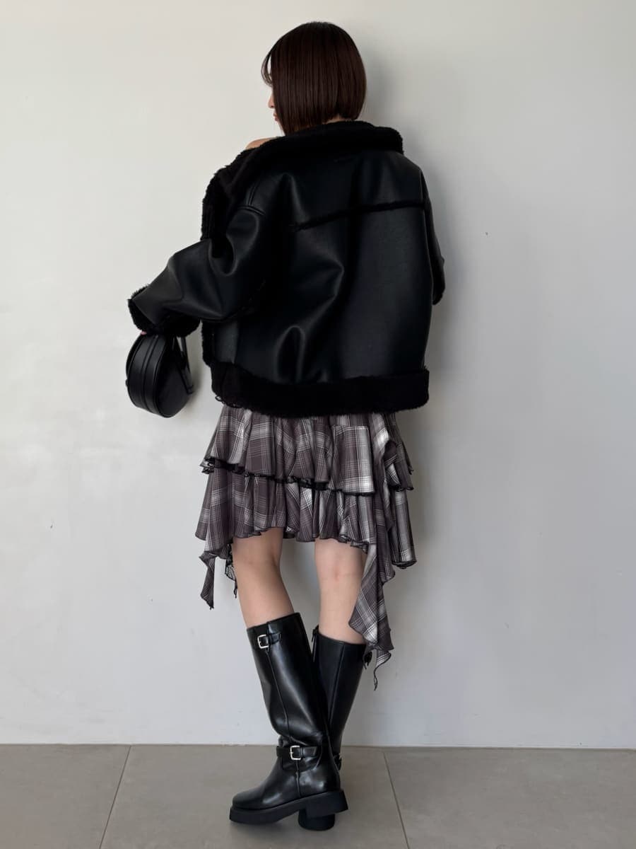 ブラック系のブーツ、ブラック系のハンドバッグ、ブラック系のブルゾンを着用したレディースの秋コーディネートの4枚目の写真