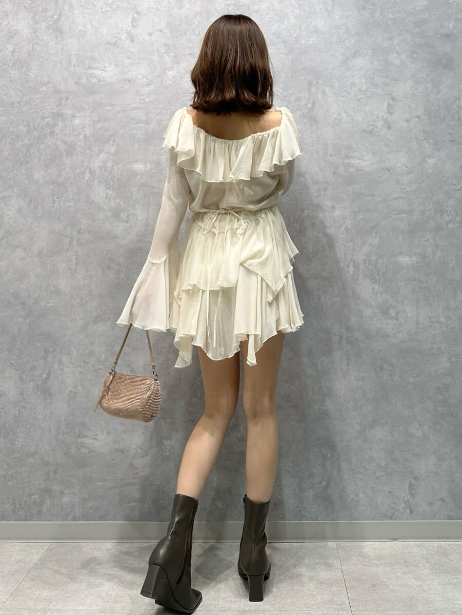 グレー系のステンカラーコート、ホワイト系のワンピースを着用したレディースの秋コーディネートの7枚目の写真