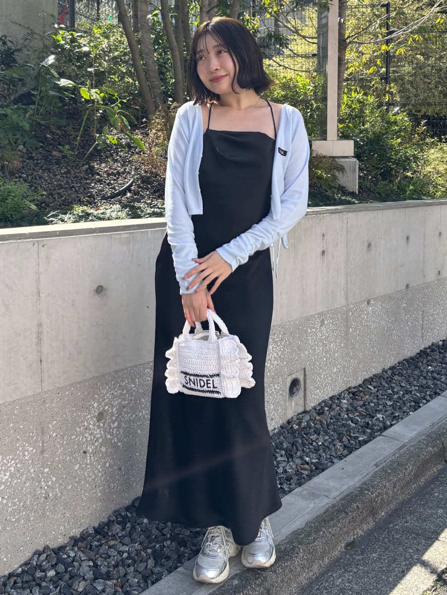 シルバー系のスニーカー、ブラック系のワンピースを着用したレディースの春コーディネートの2枚目の写真