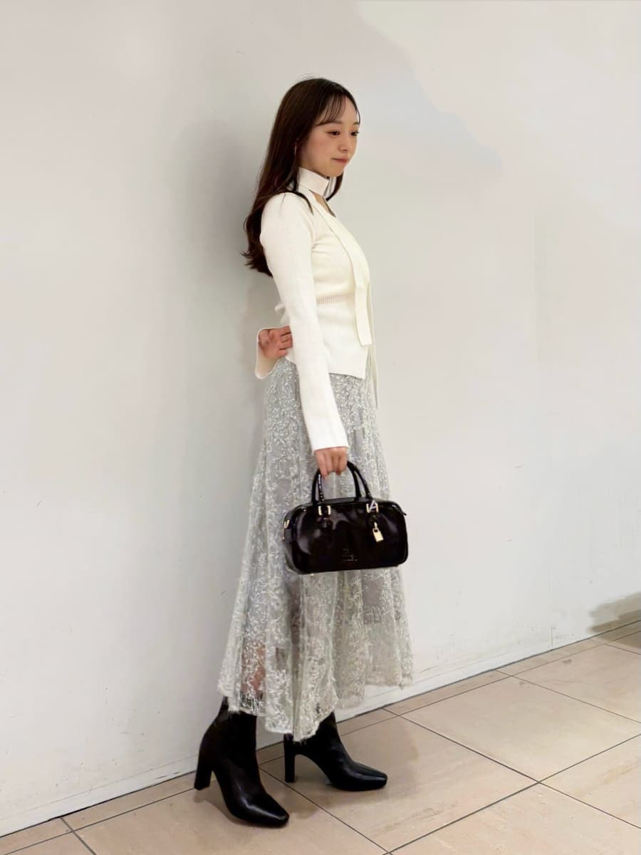 ホワイト系のニット/セーター、グリーン系のスカート、ブラック系のブーツを着用したレディースの秋コーディネートの3枚目の写真