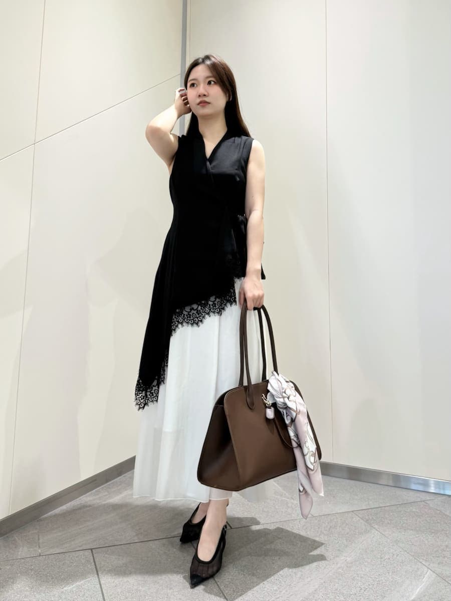 ブラック系のワンピース、ブラウン系のトートバッグ、ピンク系のバンダナ/スカーフを着用したレディースの春コーディネートの3枚目の写真