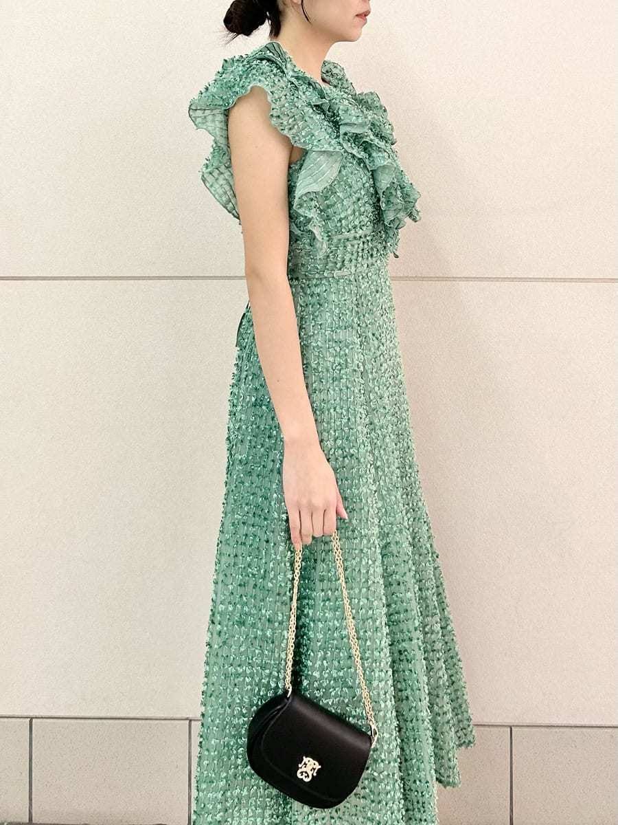 グリーン系のドレス、ブラック系のパンプス、ブラック系のショルダーバッグを着用したレディースの春コーディネートの6枚目の写真