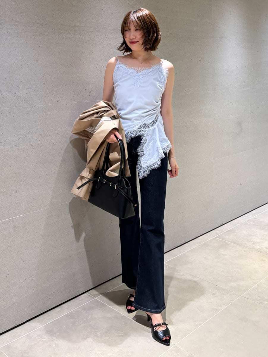 ブルー系のデニムパンツ、ベージュ系のトレンチコート、ブルー系のキャミソールを着用したレディースの秋コーディネートの4枚目の写真