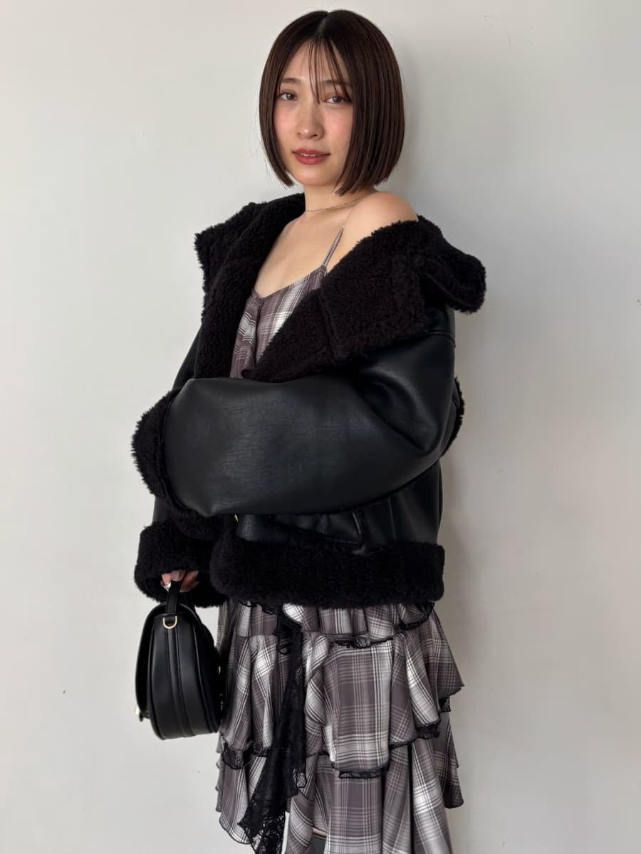 ブラック系のブーツ、ブラック系のハンドバッグ、ブラック系のブルゾンを着用したレディースの秋コーディネートの6枚目の写真