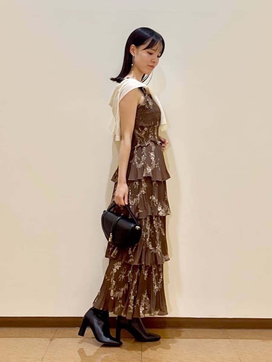 ブラウン系のワンピース、ホワイト系のカーディガン/ボレロ、ブラック系のブーツを着用したレディースの夏コーディネートの2枚目の写真
