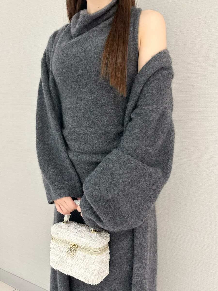 グレー系のチェスターコート、グレー系のワンピースを着用したレディースの冬コーディネートの4枚目の写真