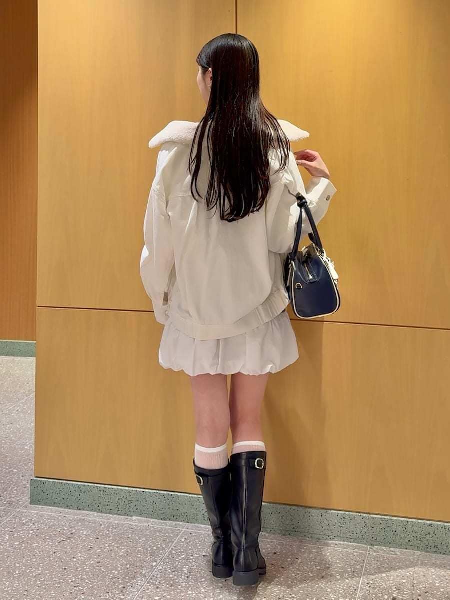 ホワイト系のブルゾン、グレー系のワンピース、ブルー系のボストンバッグを着用したレディースの春コーディネートの3枚目の写真