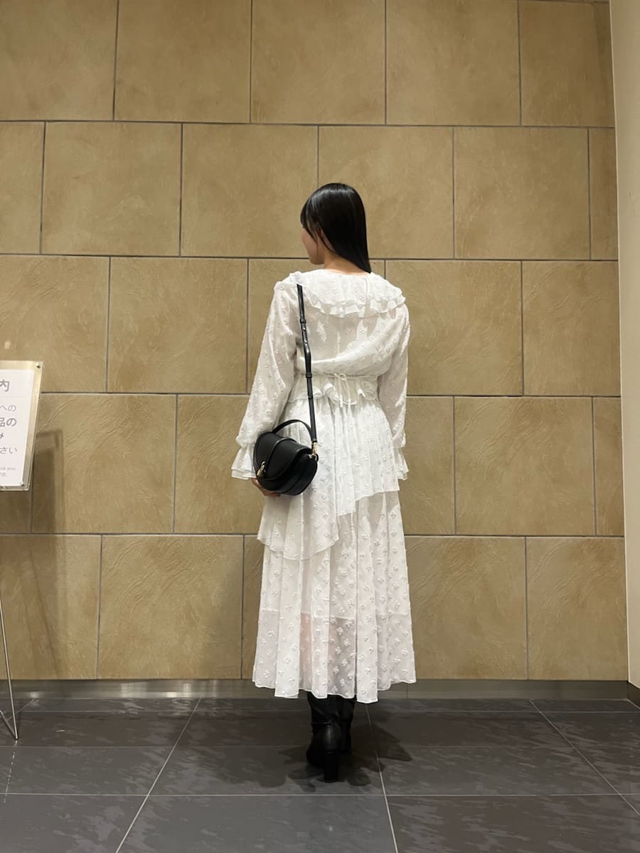 ブラック系のブーツ、ブラック系のハンドバッグ、シルバー系のスカートを着用したレディースの冬コーディネートの4枚目の写真