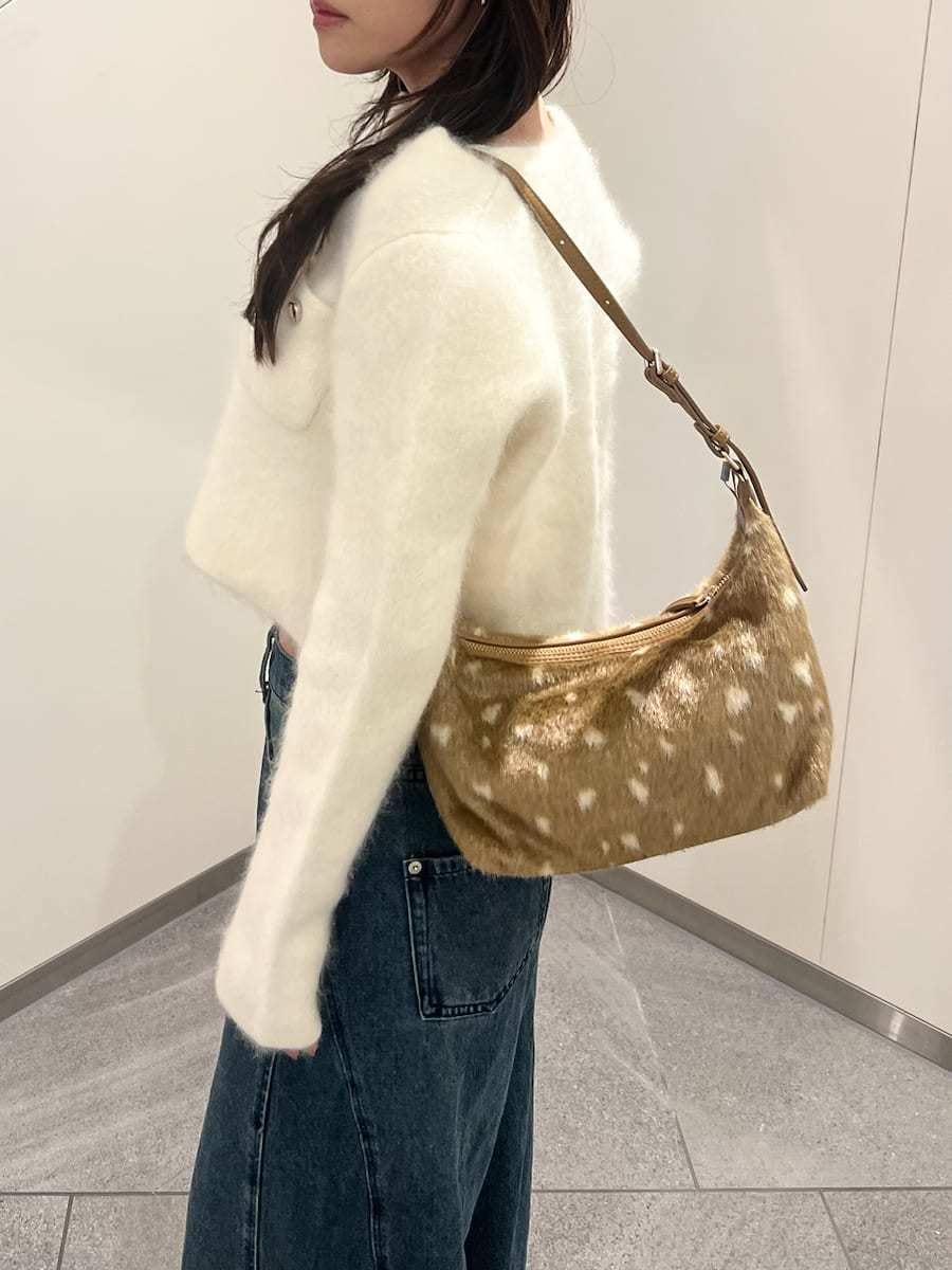 ホワイト系のノーカラージャケット、ブルー系のデニムパンツ、ホワイト系のキャミソールを着用したレディースの秋コーディネートの5枚目の写真