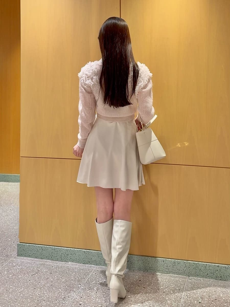 ホワイト系のその他パンツ、ピンク系のカーディガン/ボレロ、ホワイト系のブーツを着用したレディースの冬コーディネートの4枚目の写真