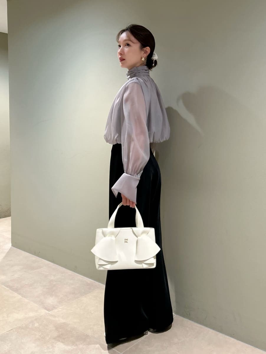 ブラック系のつなぎ/オールインワン、ホワイト系のハンドバッグを着用したレディースの冬コーディネートの3枚目の写真