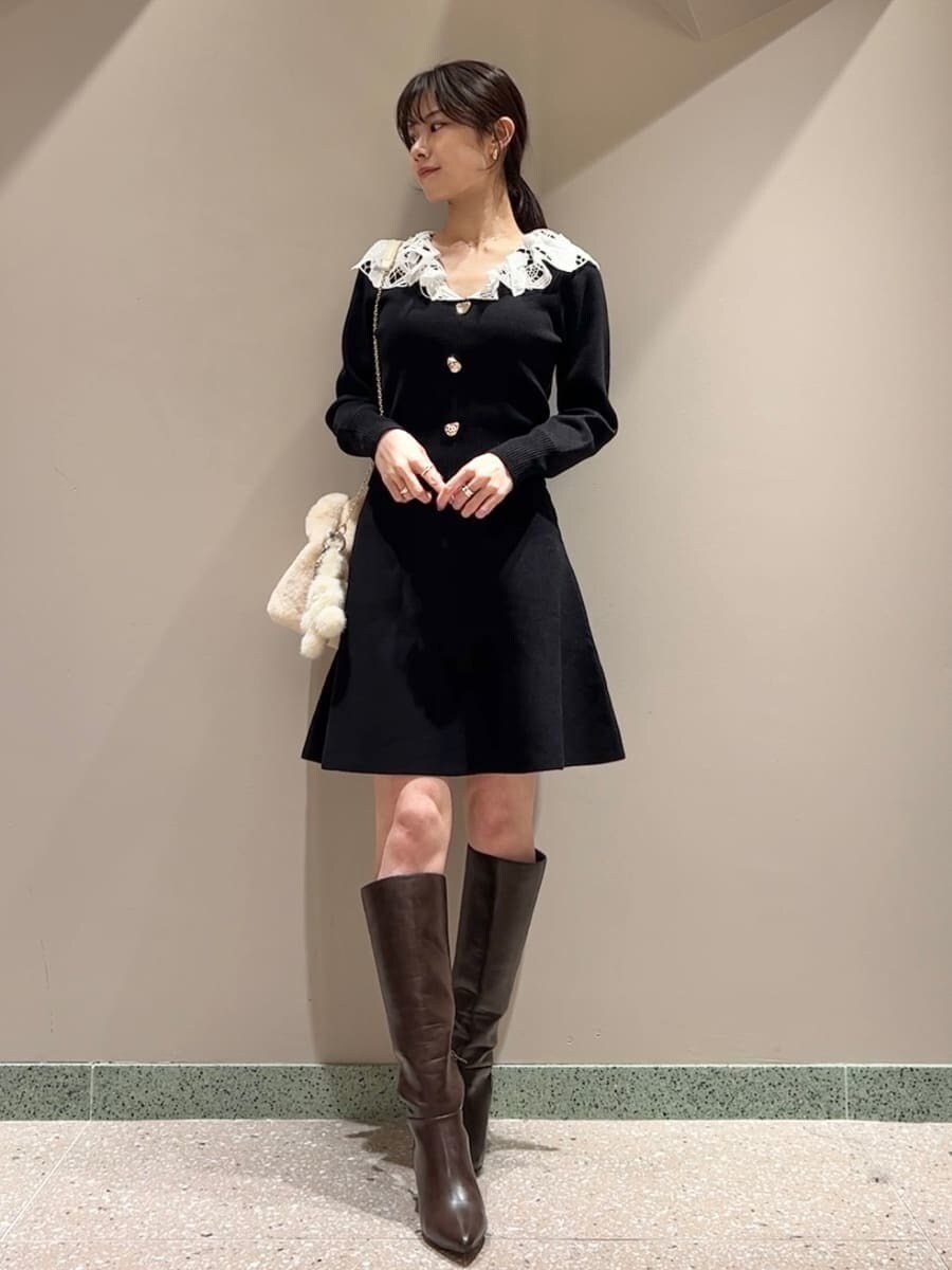 ホワイト系のステンカラーコート、イエロー系のハンドバッグ、ブラック系のワンピースを着用したレディースの冬コーディネートの6枚目の写真