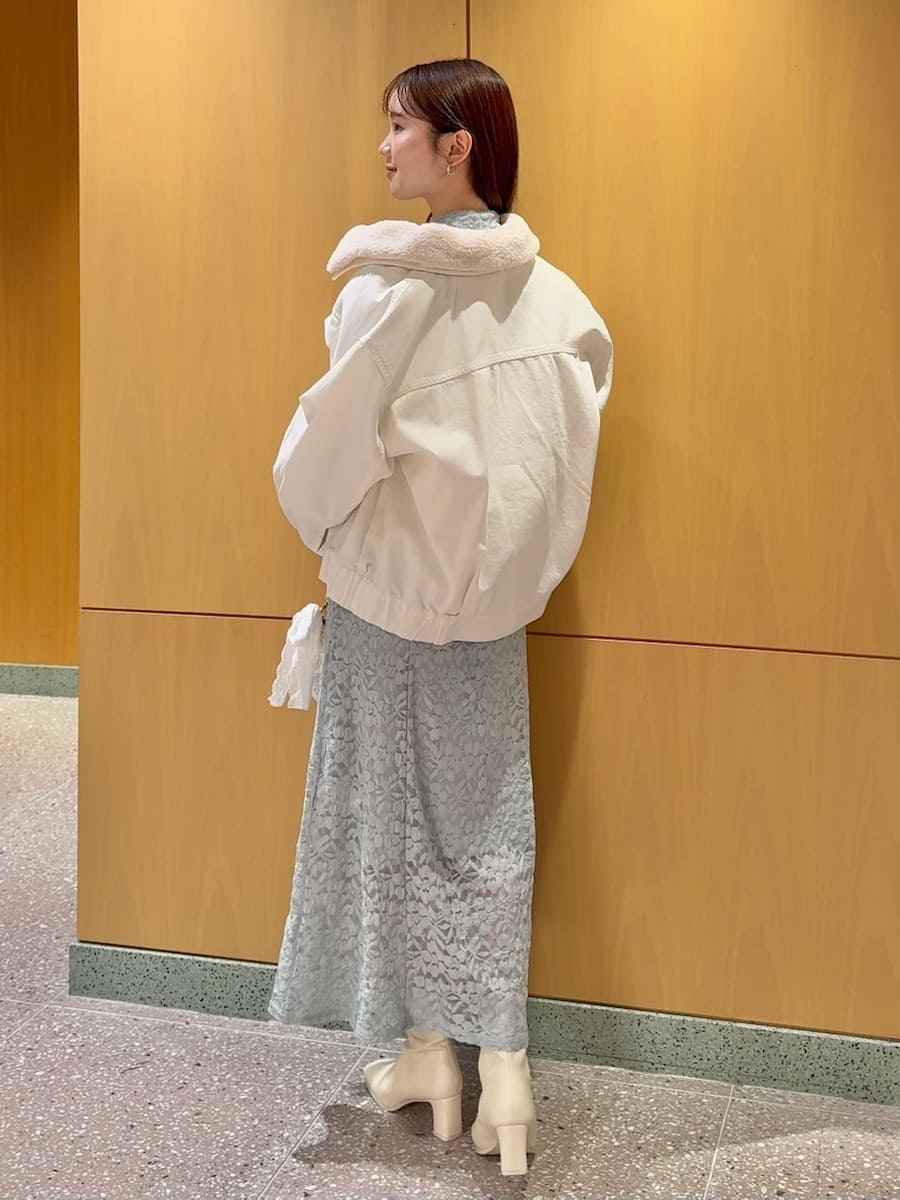 ホワイト系のブルゾン、グリーン系のワンピースを着用したレディースの冬コーディネートの2枚目の写真