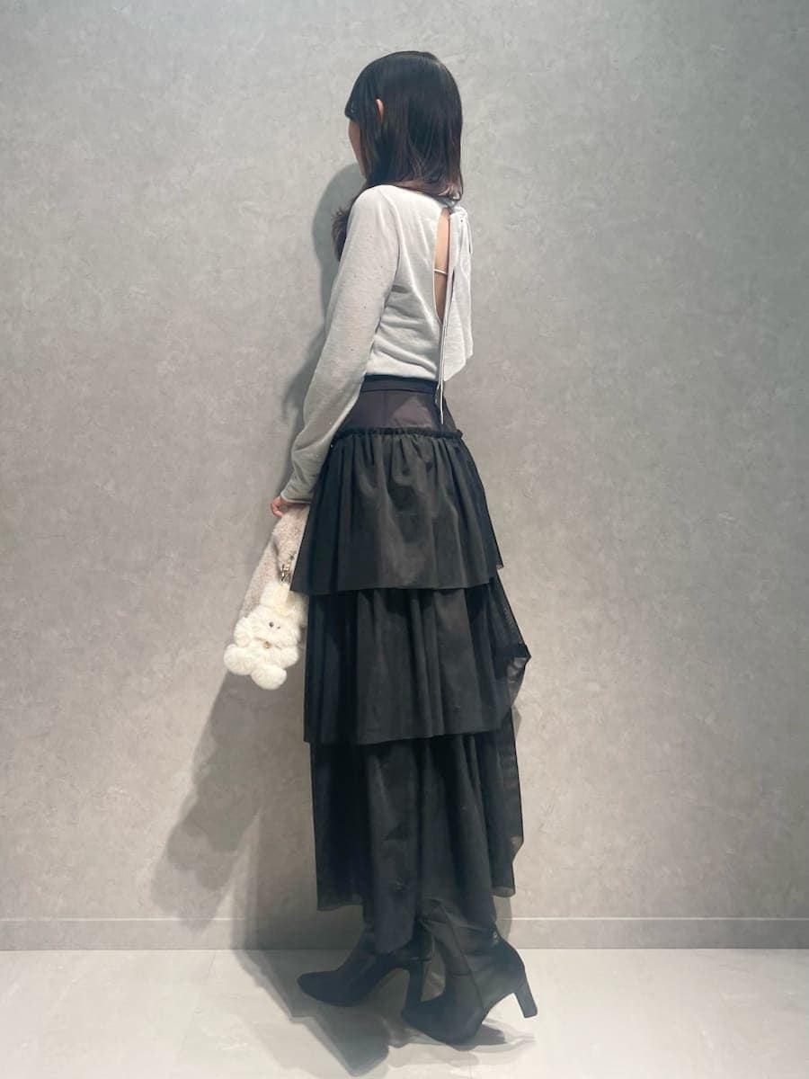 ブラック系のブーツ、グレー系のチェスターコート、ブラック系のスカートを着用したレディースの冬コーディネートの5枚目の写真