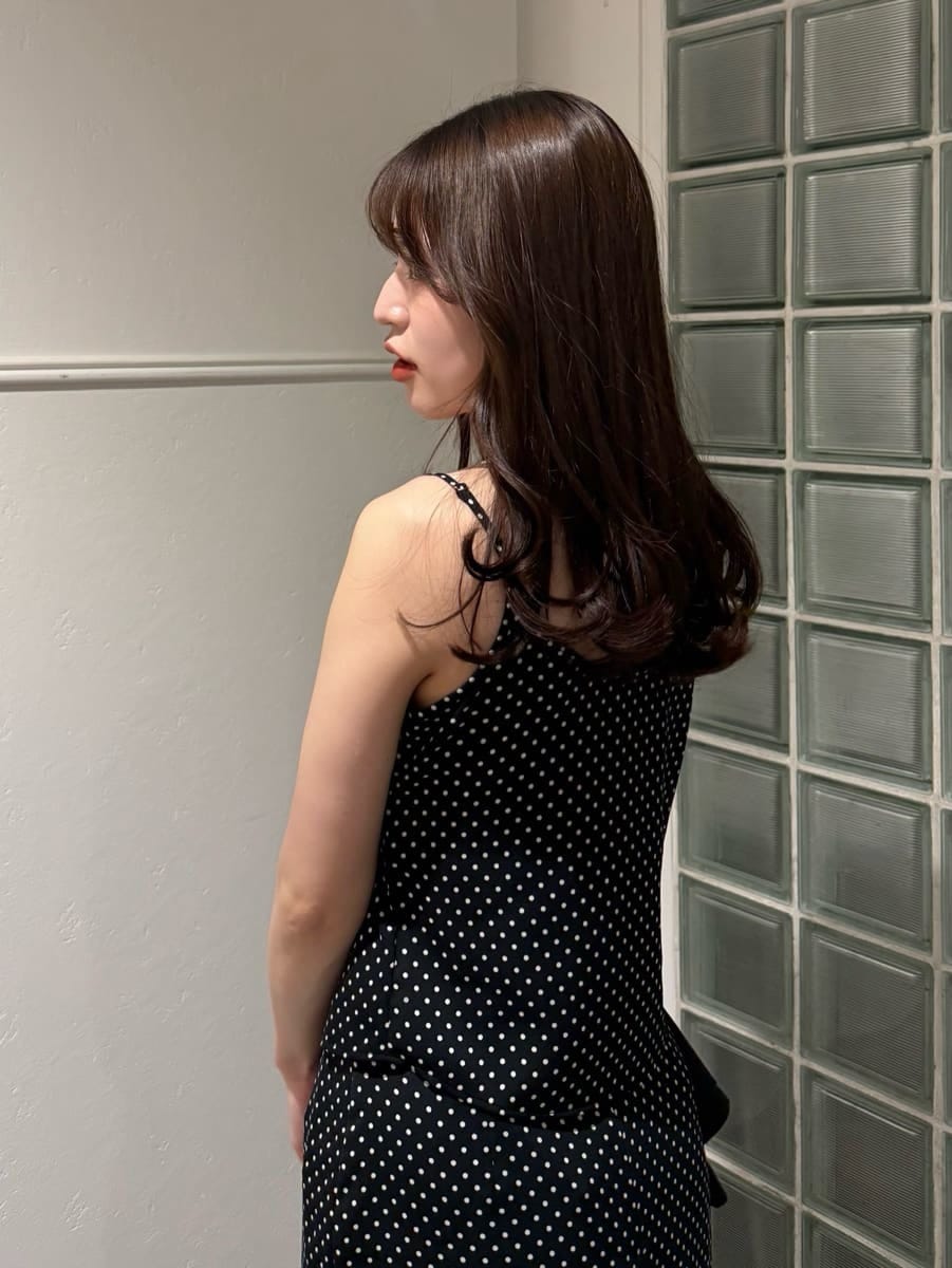 ブルー系のテーラードジャケット、ブラック系のスカート、ブラック系のキャミソールを着用したレディースの冬コーディネートの3枚目の写真