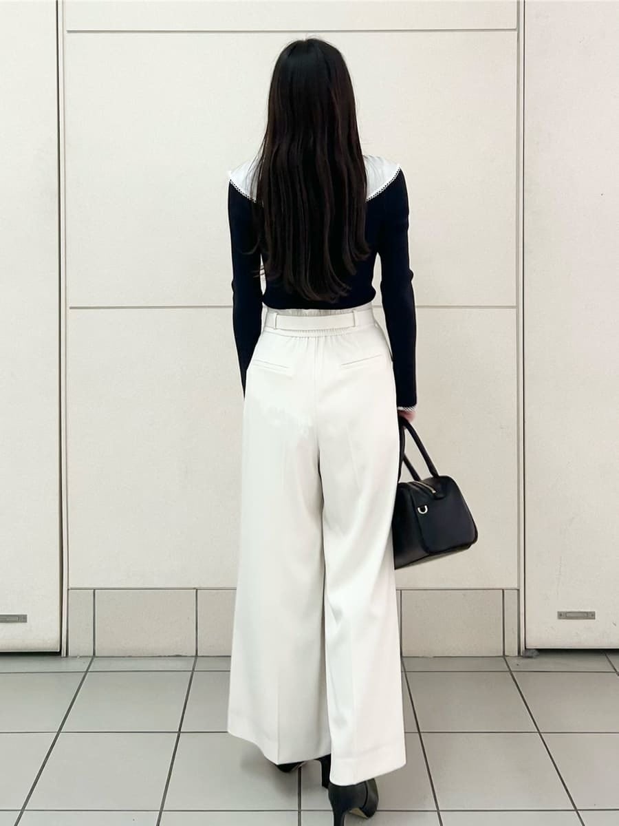 ブラック系のブーツ、ブルー系のニット/セーター、ホワイト系のその他パンツを着用したレディースの冬コーディネートの4枚目の写真