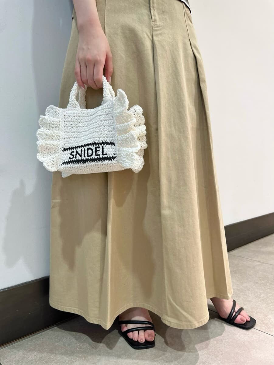 ベージュ系のスカート、グリーン系のTシャツ/カットソー、ホワイト系のショルダーバッグを着用したレディースの春コーディネートの5枚目の写真