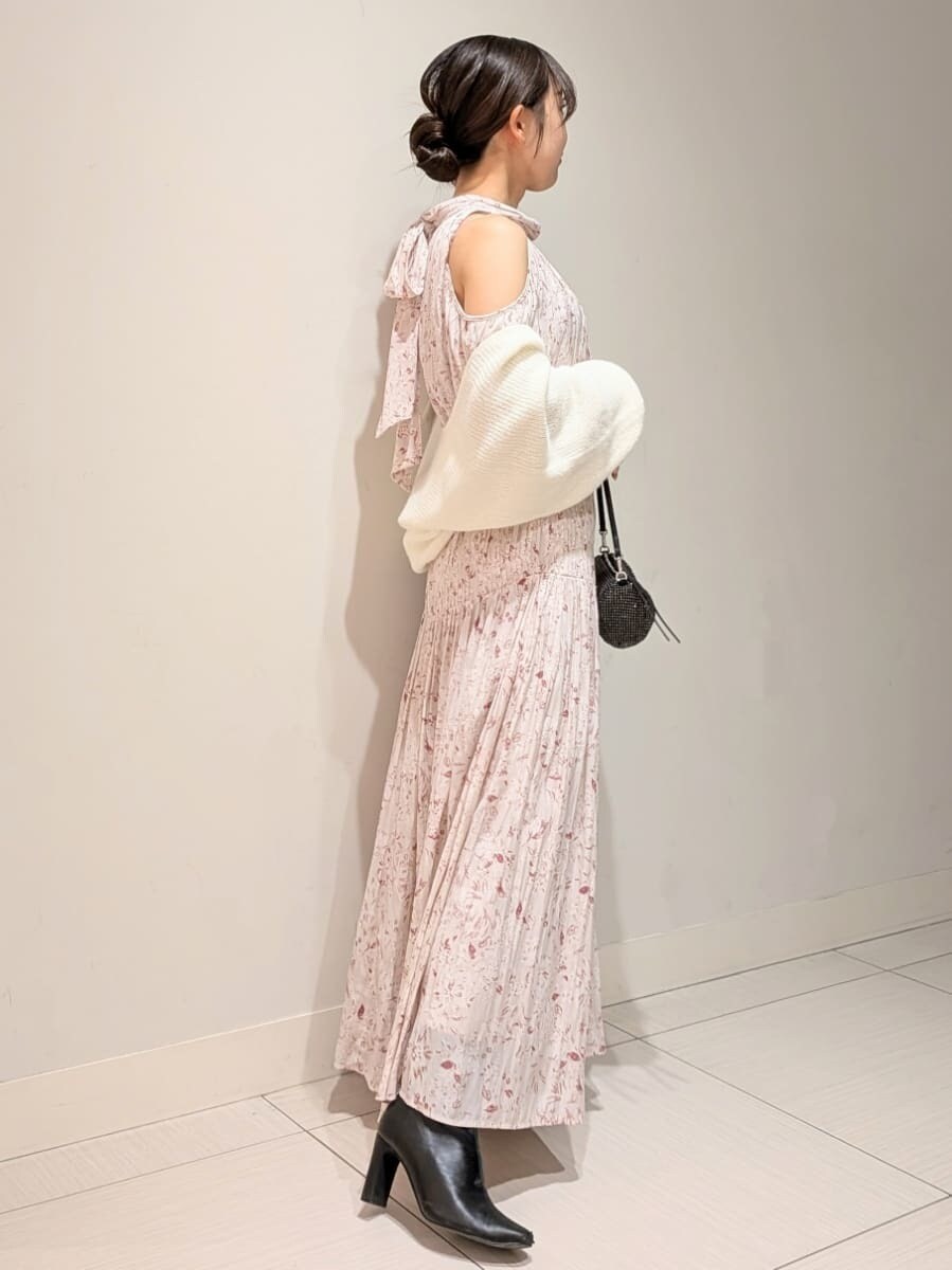 ブラック系のブーツ、ピンク系のワンピース、ホワイト系のカーディガン/ボレロを着用したレディースの冬コーディネートの2枚目の写真