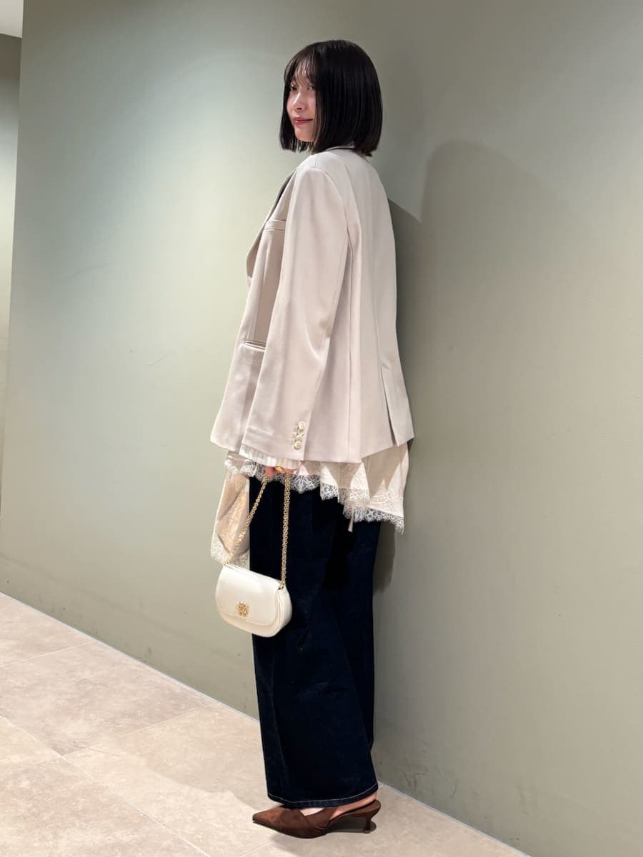 ベージュ系のテーラードジャケット、ブルー系のデニムパンツ、ホワイト系のキャミソールを着用したレディースの春コーディネートの4枚目の写真