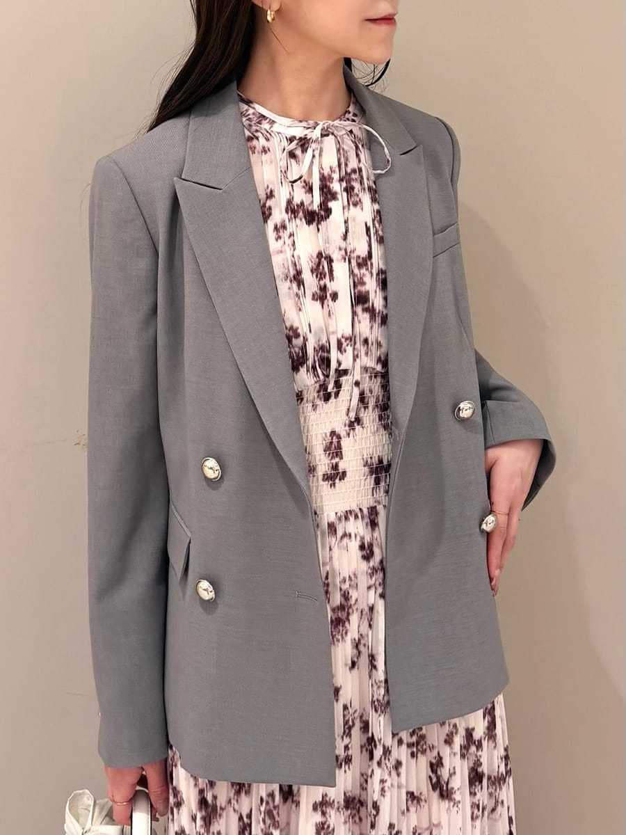 ピンク系のワンピース、グレー系のテーラードジャケット、ブラウン系のパンプスを着用したレディースの冬コーディネートの4枚目の写真