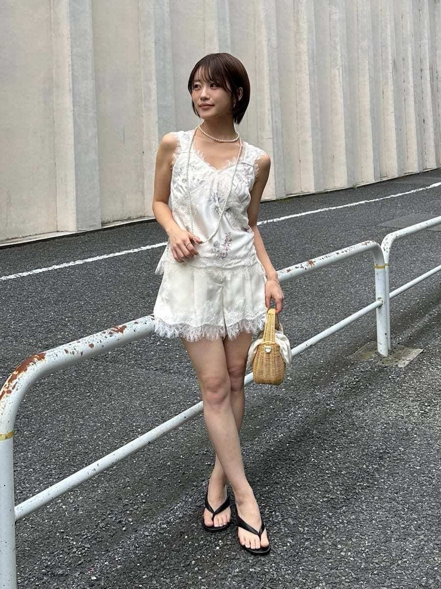 ホワイト系のかごバッグ、その他のキャミソール、ホワイト系のその他パンツを着用したレディースの夏コーディネートの5枚目の写真