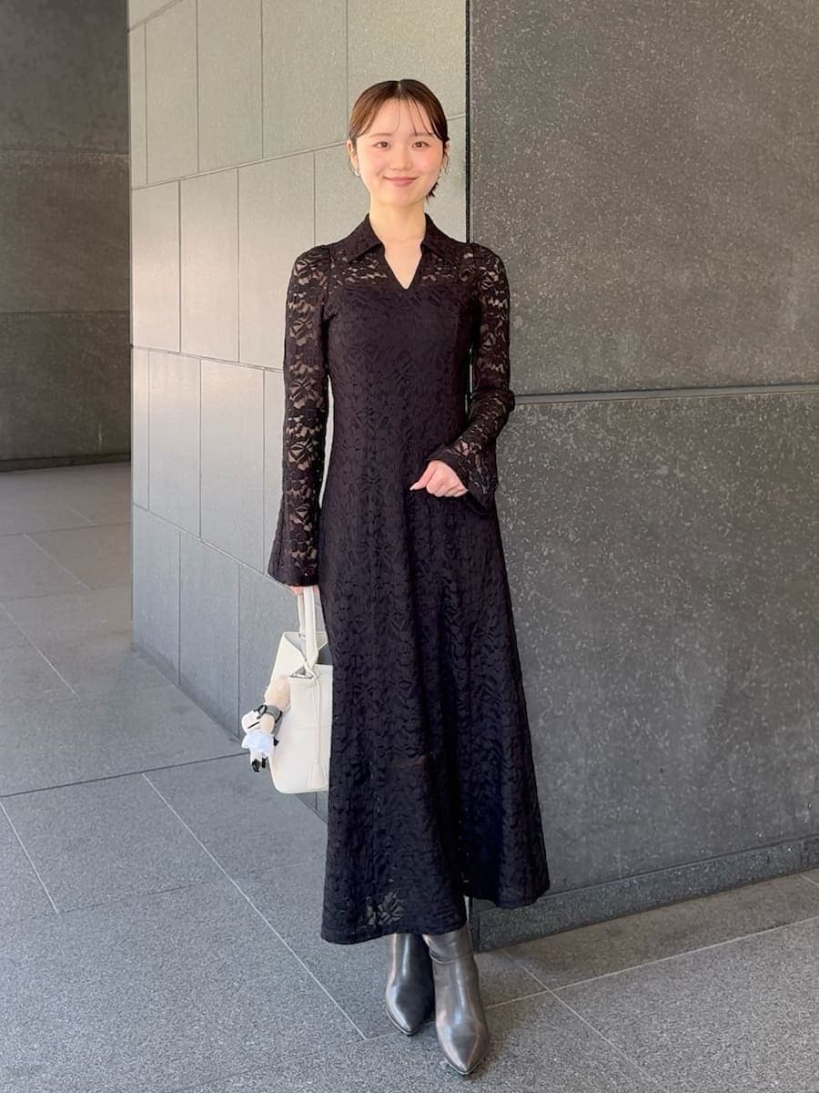 グレー系のブーツ、ブラック系のワンピース、ホワイト系のハンドバッグを着用したレディースの冬コーディネートの4枚目の写真