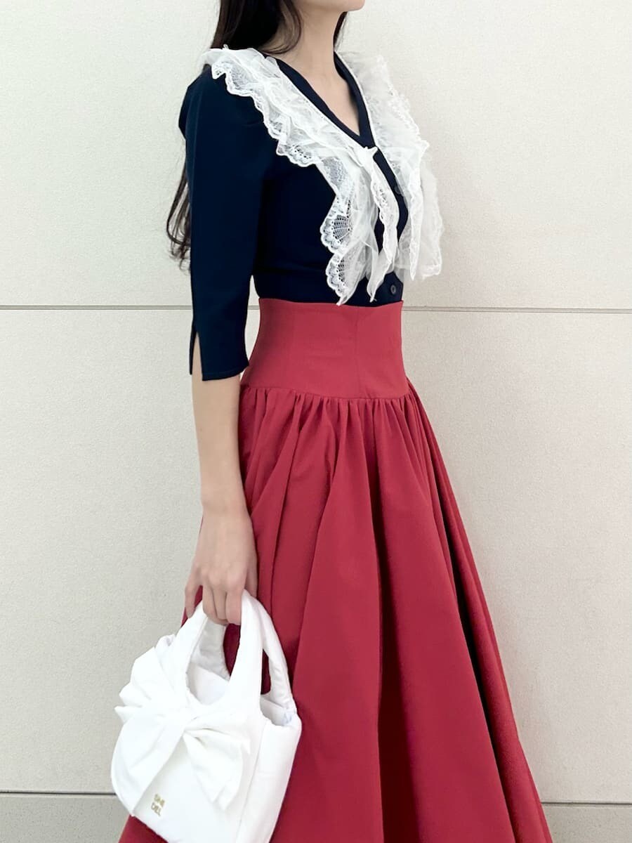 ブラック系のブーツ、ブルー系のニット/セーター、レッド系のスカートを着用したレディースの冬コーディネートの6枚目の写真