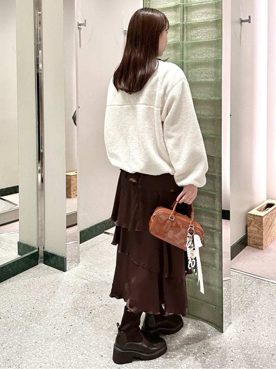 ホワイト系のTシャツ/カットソー、ブラウン系のスカート、イエロー系のボストンバッグを着用したレディースの秋コーディネートの5枚目の写真