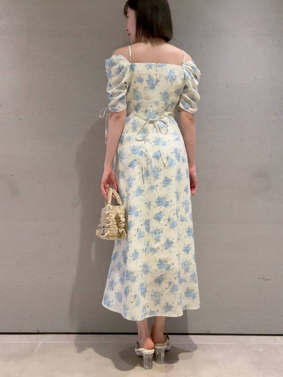 ベージュ系のショルダーバッグ、イエロー系のワンピースを着用したレディースの春コーディネートの4枚目の写真